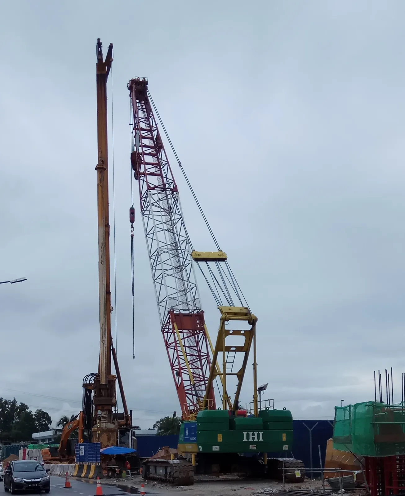 Crawler crane with long lattice boom working on a piling site