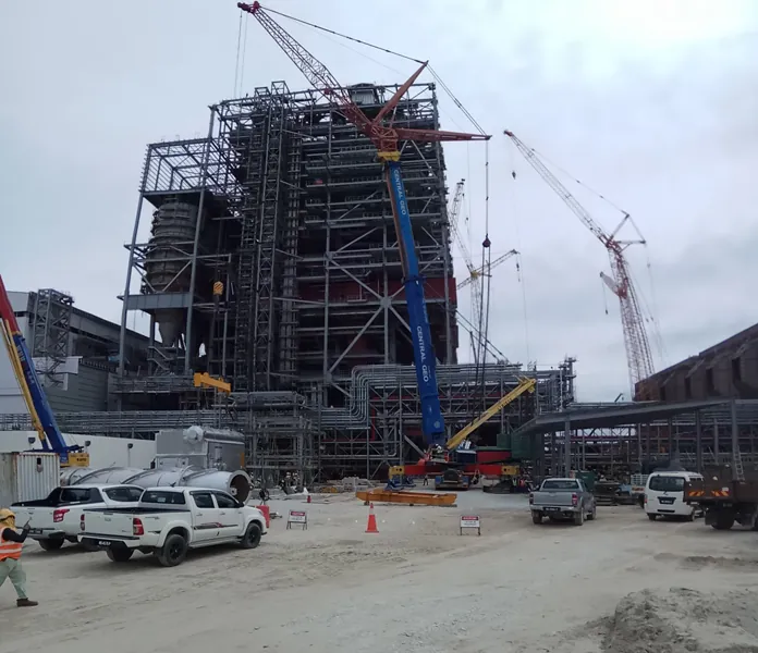 Mobile crane with luffing jib positioning a boiler section
