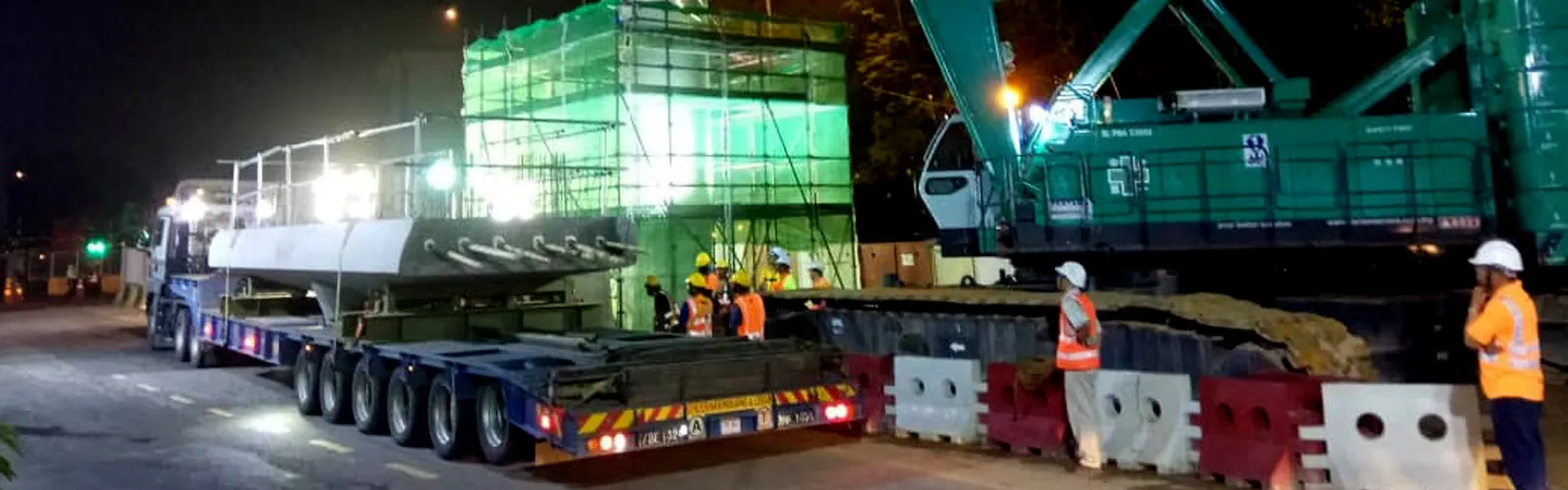 Pertama Crane crawler crane lifting a heavy module onto a multi-axle trailer at night